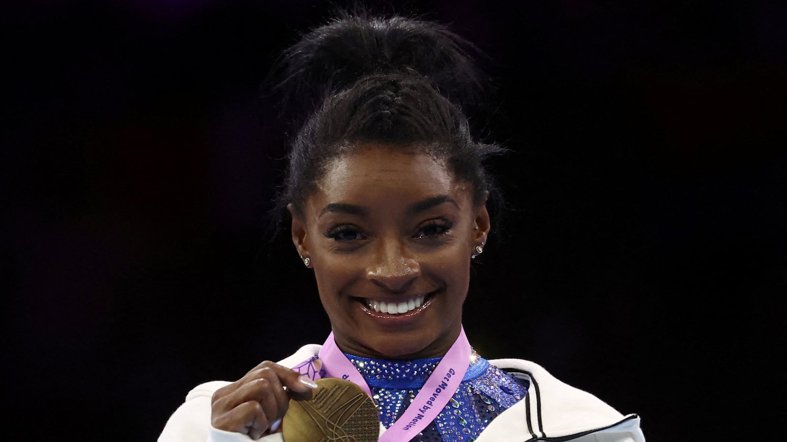 Simone Biles of the U.S. celebrates on the podium after winning the women's individual all-around final
