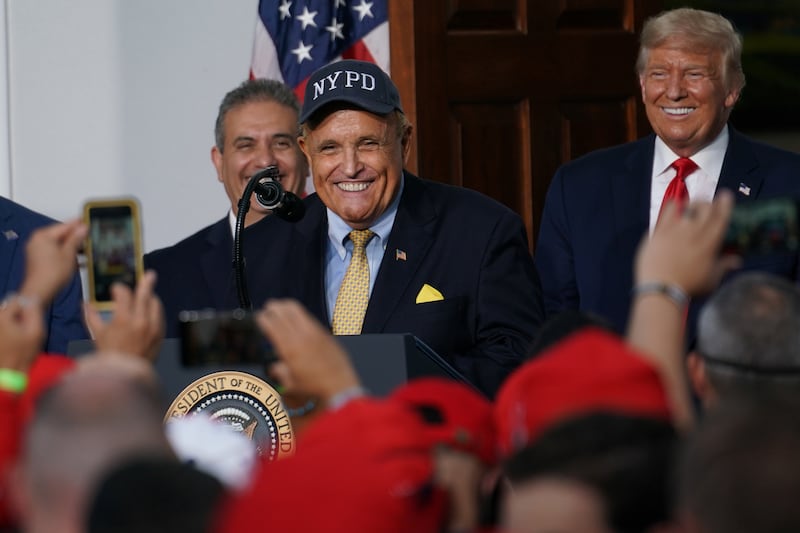 Former New York City Mayor Rudy Giuliani, next to U.S. President Donald Trump, who he says has been checking in on him since he got out of a coma.