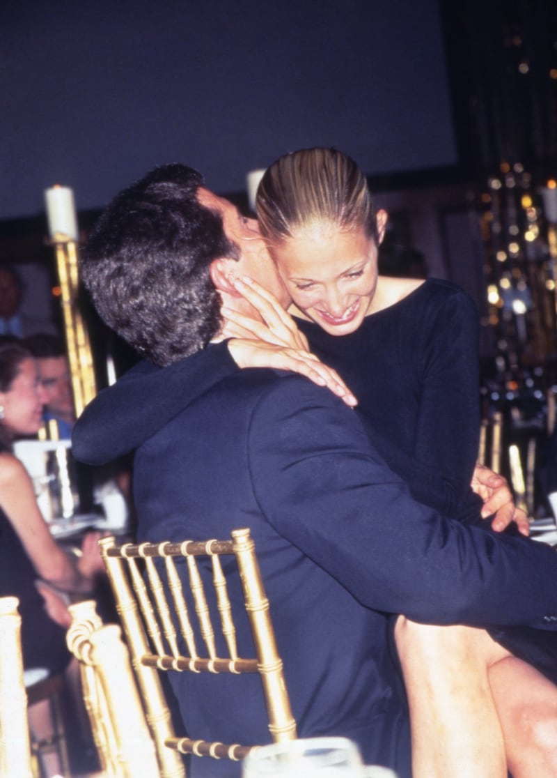 Carolyn Bessette-Kennedy sits on her husband John F. Kennedy Jr.'s lap while attending a function at the Hilton Hotel in New York on June 1, 1996.