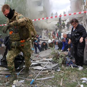 People remove debris while searching for survivors following the collapse of a section of an apartment block in the city of Belgorod, Russia, May 12, 2024. 