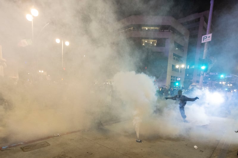 A smoke bomb fill the air as police clash with protesters during a demonstration following federal immigration operations in Los Angeles on June 9, 2025.