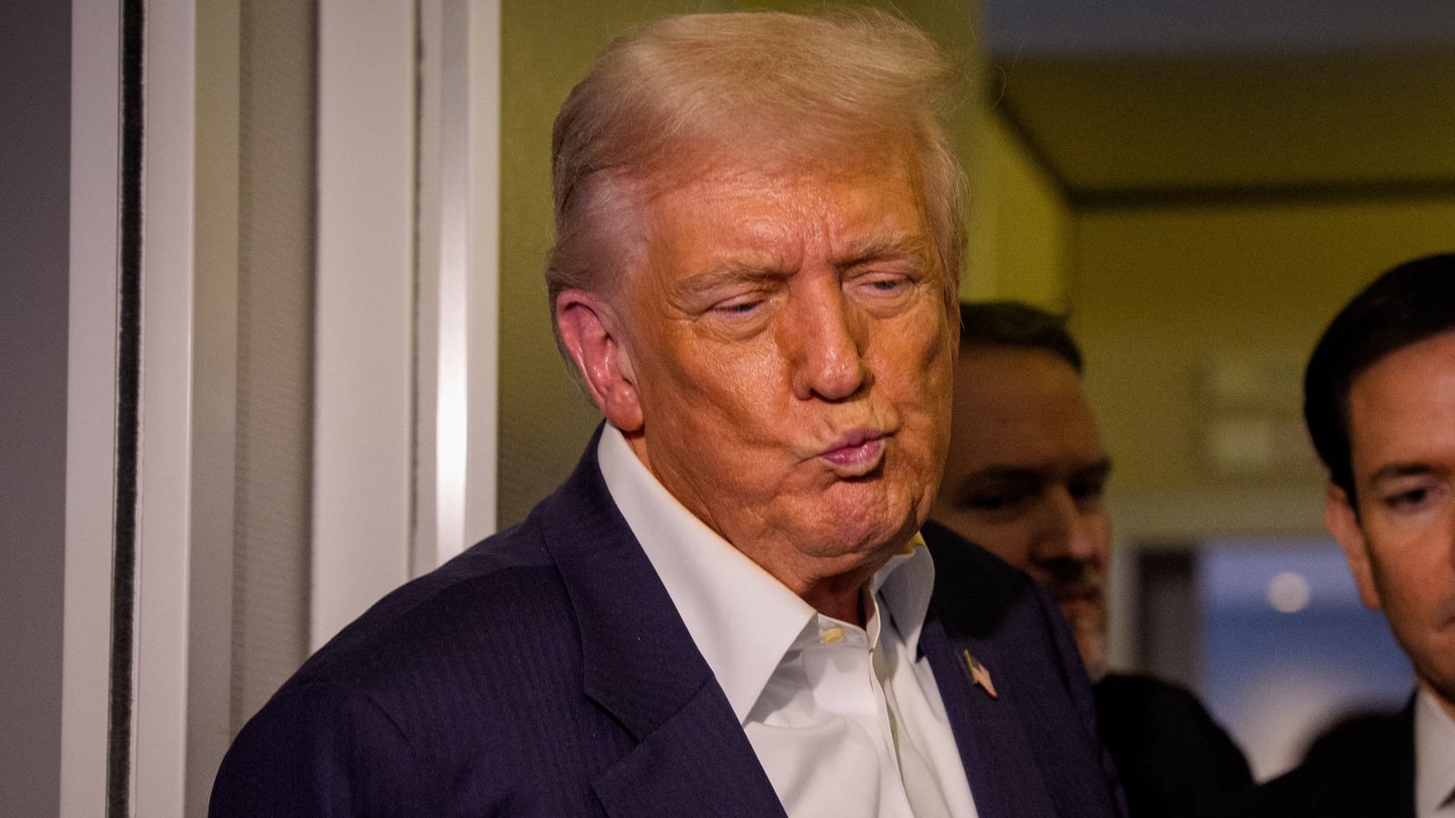 U.S. President Donald Trump, accompanied by U.S. Secretary of State Marco Rubio (R), takes a question from a reporter aboard Air Force One on October 27, 2025, in flight.