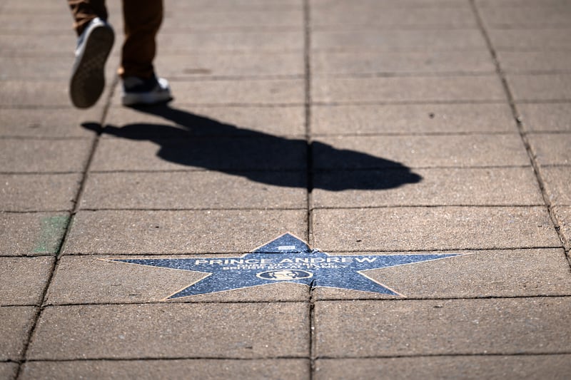A person walks past a star with the name of former British prince Andrew Mountbatten-Windsor along the "Jeffrey Epstein Walk of Shame," which features prominent names that appear in the Epstein files, near the White House on March 1, 2026, in Washington, DC.