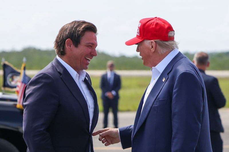 U.S. President Donald Trump gestures as he speaks with Florida Governor Ron DeSantis at the Dade-Collier Training and Transition Airport on the day of the opening of a temporary migrant detention center informally known as "Alligator Alcatraz" in Ochopee, Florida, U.S., July 1, 2025. REUTERS/Evelyn Hockstein