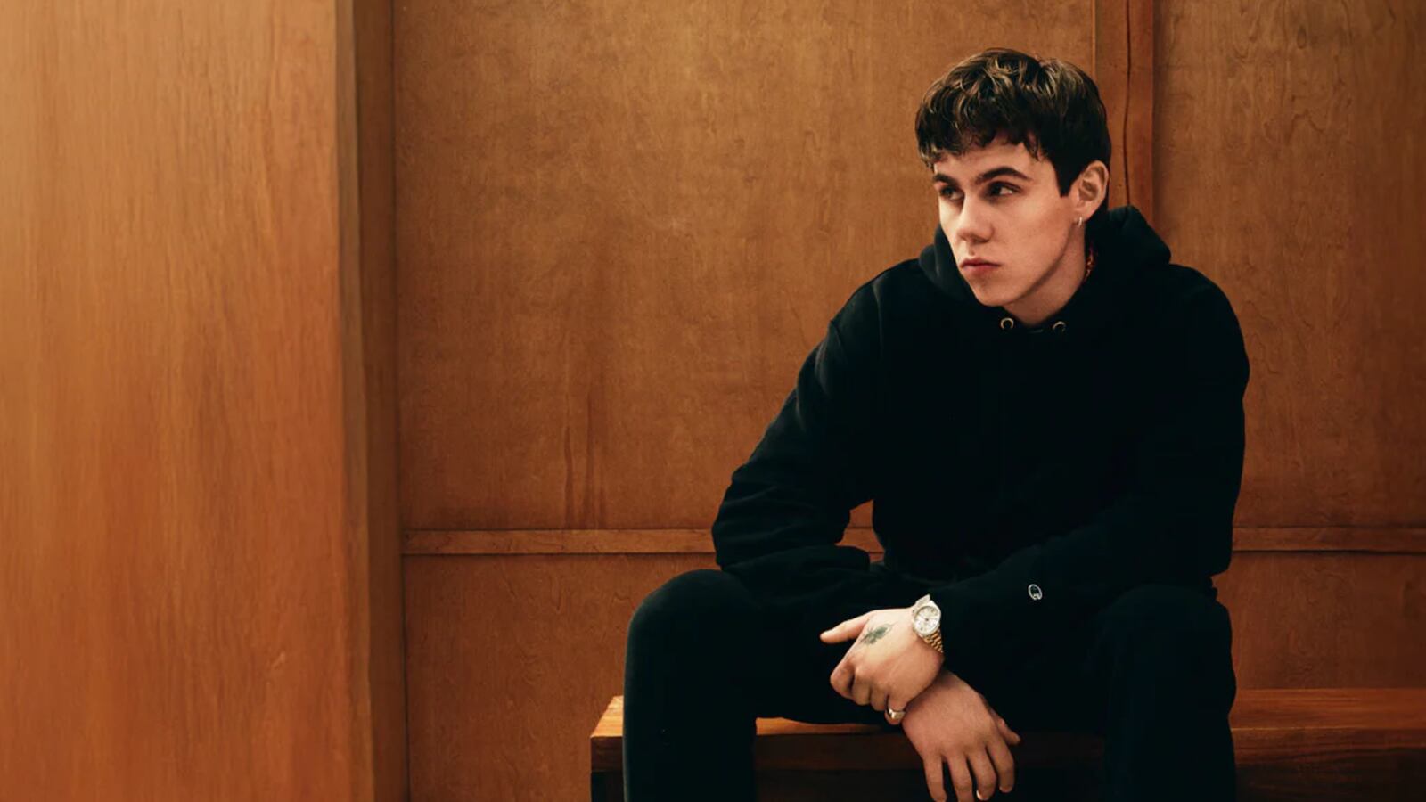 Man sitting wearing Reverse Wear hoodie and joggers from Champion