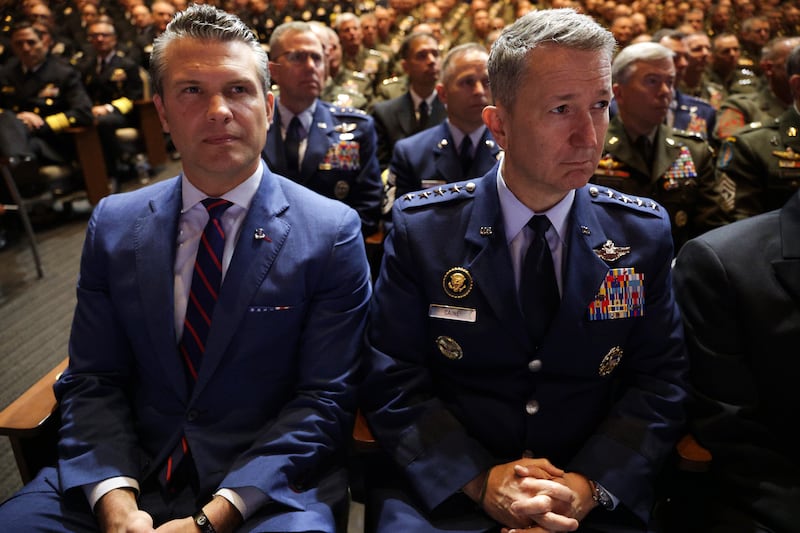 QUANTICO, VIRGINIA - SEPTEMBER 30: U.S. Secretary of War Pete Hegseth (L) and Chairman of the Joint Chiefs of Staff Air Force Gen. Dan Caine listen as U.S. President Donald Trump speaks to senior military members at Marine Corps Base Quantico on September 30, 2025 in Quantico, Virginia. In an unprecedented gathering, almost 800 generals, admirals and their senior enlisted leaders have been ordered into one location from around the world on short notice. (Photo by Alex Wong/Getty Images)