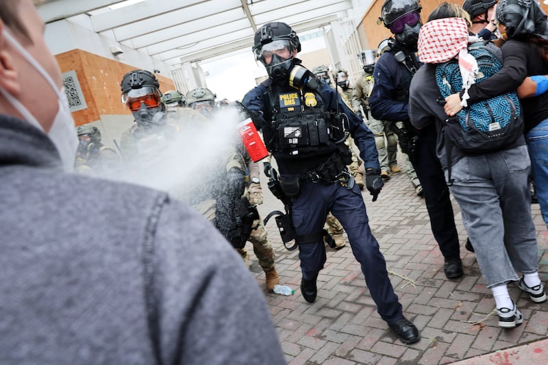 PORTLAND, OREGON - OCTOBER 04: Federal agents, including members of the Department of Homeland Security, the Border Patrol, and police, clash with protesters outside a downtown U.S. Immigration and Customs Enforcement (ICE) facility on October 04, 2025 in Portland, Oregon. The facility has become a focal point of nightly protests against the Trump administration and his announcement that he will be sending National Guard troops into Portland. A federal judge is currently hearing Oregon’s case against sending troops into the city, and a decision is expected on Saturday. (Photo by Spencer Platt/Getty Images)