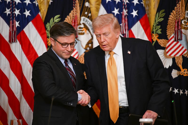 US President Donald Trump shakes hands with US Speaker of the House Mike Johnson (L), Republican from Louisiana as he arrives during a lunch with the Kennedy Center Board Members in the East Room of the White House on March 16, 2026 in Washington, DC. (Photo by Annabelle GORDON / AFP via Getty Images)