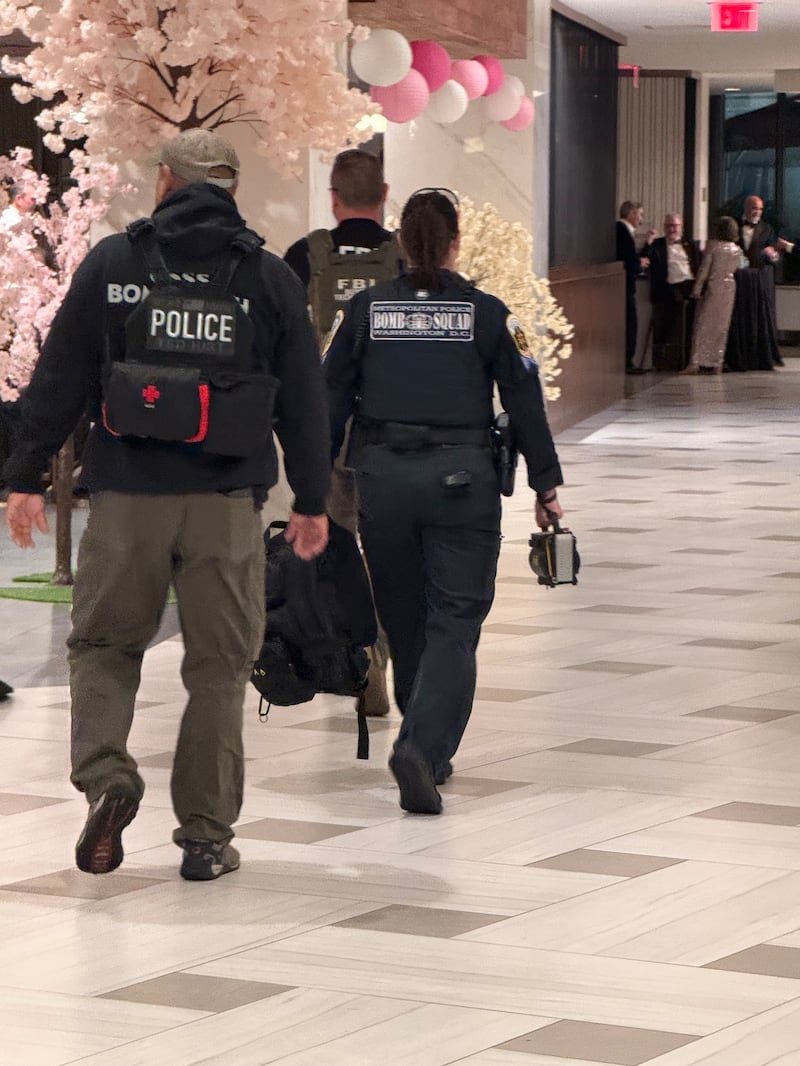 Unformed people one wearing a Bomb Squad bulletrproof vest