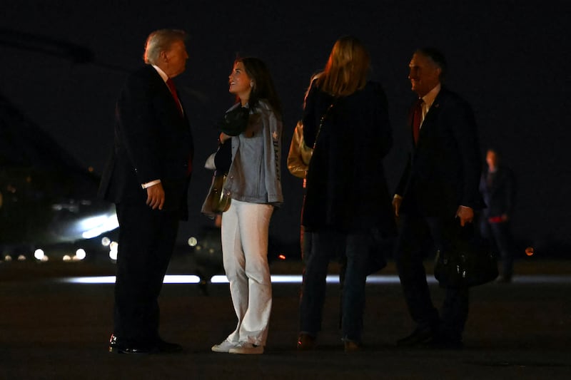 Donald Trump (L) talks with his granddaughter Kai Trump before boarding Air Force One.