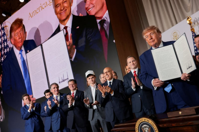 US President Donald Trump shows a signed Executive Order related to a new AI-powered government website, America.gov, during the National Design Studio launch event of the website at the Mellon Auditorium in Washington, D.C., US, September 29, 2026. REUTERS/Jonathan Ernst   REFILE - ADDING INFORMATION ABOUT THE DOCUMENT