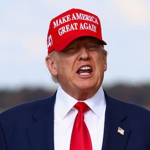 U.S. President Donald Trump speaks, while wearing a "Make America Great Again" cap, after disembarking Air Force One, as he returns from his Asia trip, at Joint Base Andrews, Maryland, U.S., October 30, 2025.