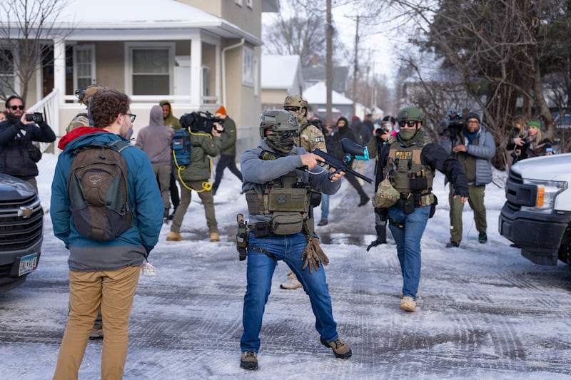 Federal agents forcefully push through a crowd of bystanders as they attempt to leave the scene where a woman was fatally shot by a federal agent earlier, in Minneapolis, Minn., on Wednesday, January 7, 2026.