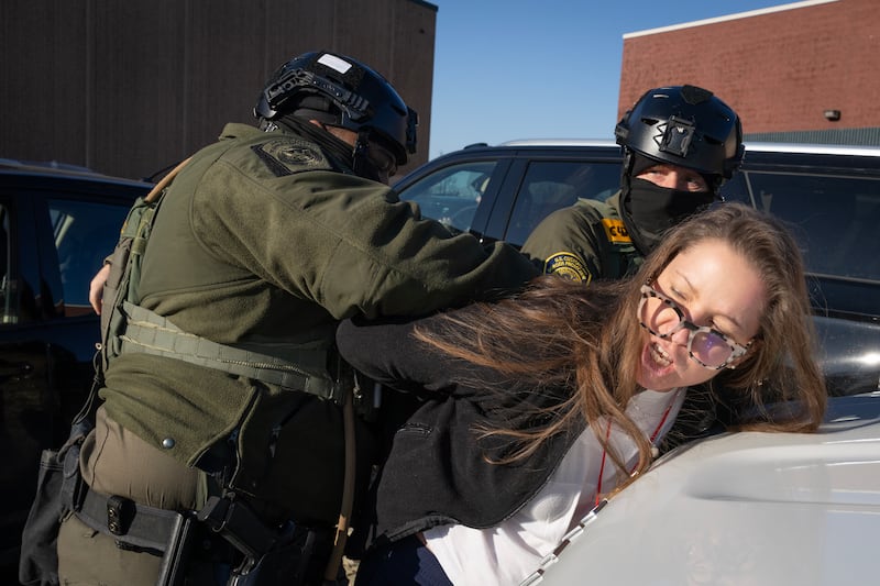 A woman is taken into custody by Border Patrol agents after she was accused of using her vehicle to block their vehicles