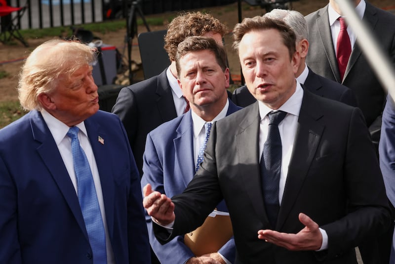 SpaceX AI Founder and CEO Elon Musk speaks to the media as Trump listens on the White House driveway following a luncheon for tech leaders in the East Room.