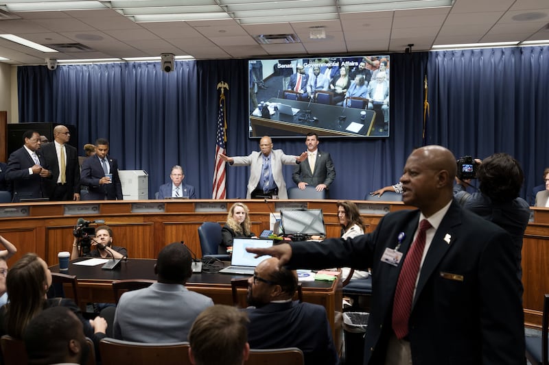 A member of the staff tries to calm the crowd during a public hearing on redistricting as Louisiana Republicans pursue a new congressional voting map ahead of the November midterm elections, in Baton Rouge, Louisiana, U.S., May 8, 2026.