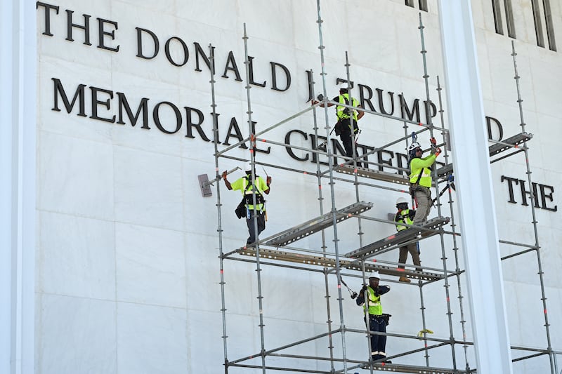 Workers stand on scaffolding near the signage for the Donald J. Trump and John F. Kennedy Memorial Center for the Performing Arts in Washington, DC, on June 12, 2026.