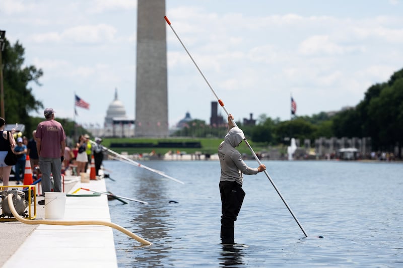 Workers vacuum algae from the Lincoln Memorial Reflecting Pool, after recent renovations following a directive from U.S. President Donald Trump to paint it blue ahead of the 250th anniversary of U.S. Independence, in Washington, D.C., U.S., June 21, 2026.