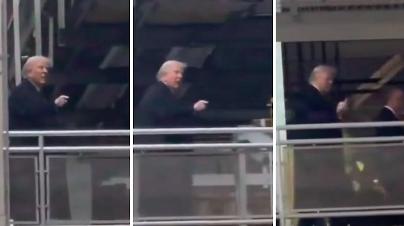 Donald Trump points and flips the bird at a factory worker.