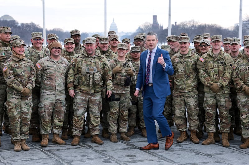 U.S. Defense Secretary Pete Hegseth poses with U.S. Army National Guard soldiers.