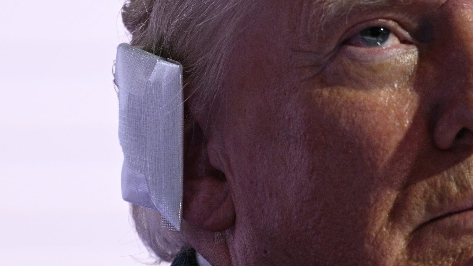 Donald Trump wears a bandage on his ear after surviving an assassination attempt as he stands onstage during the last day of the 2024 Republican National Convention at the Fiserv Forum in Milwaukee, Wisconsin, on July 18, 2024.