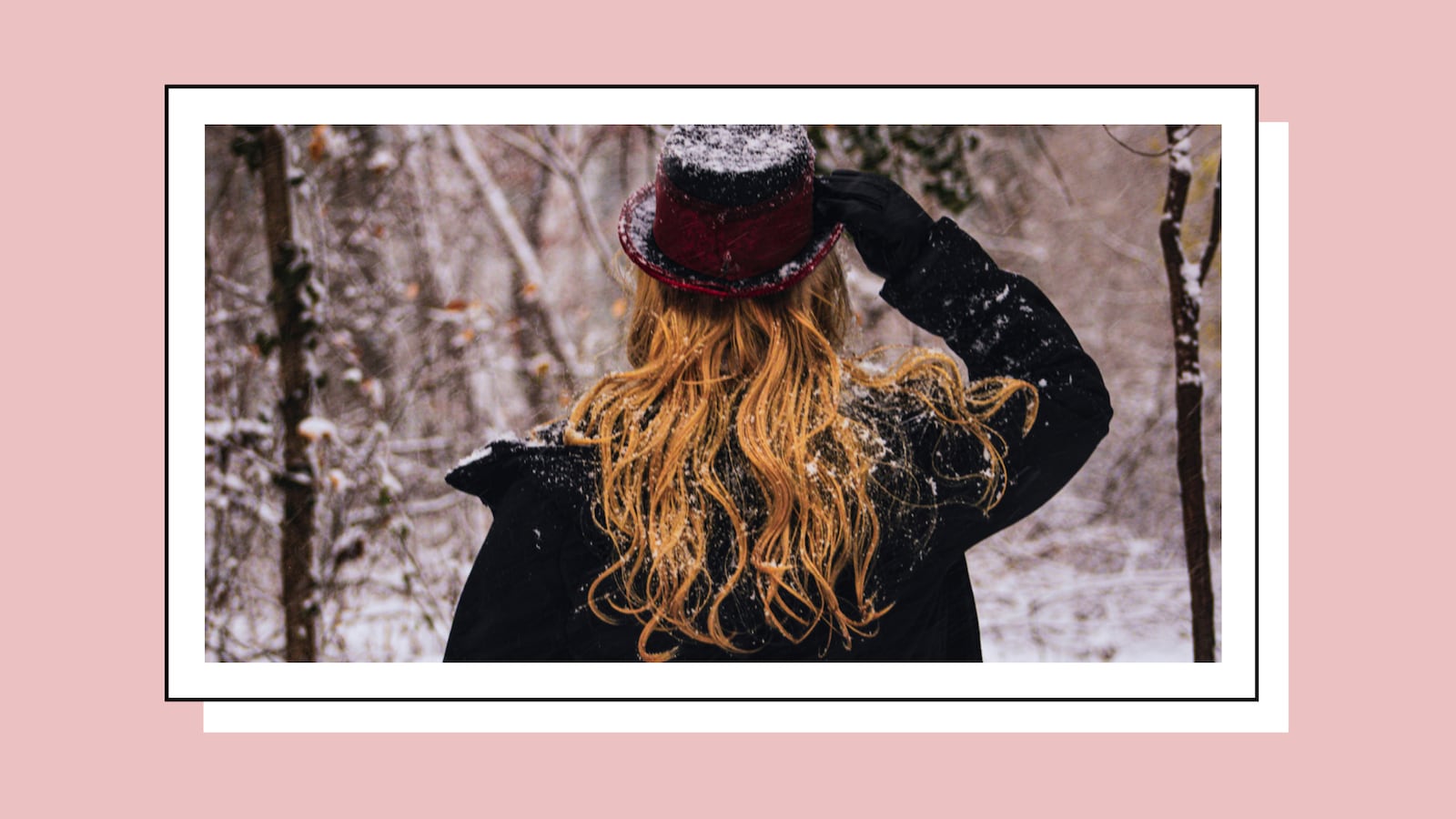 Red-haired woman wearing a top hat in the snow.