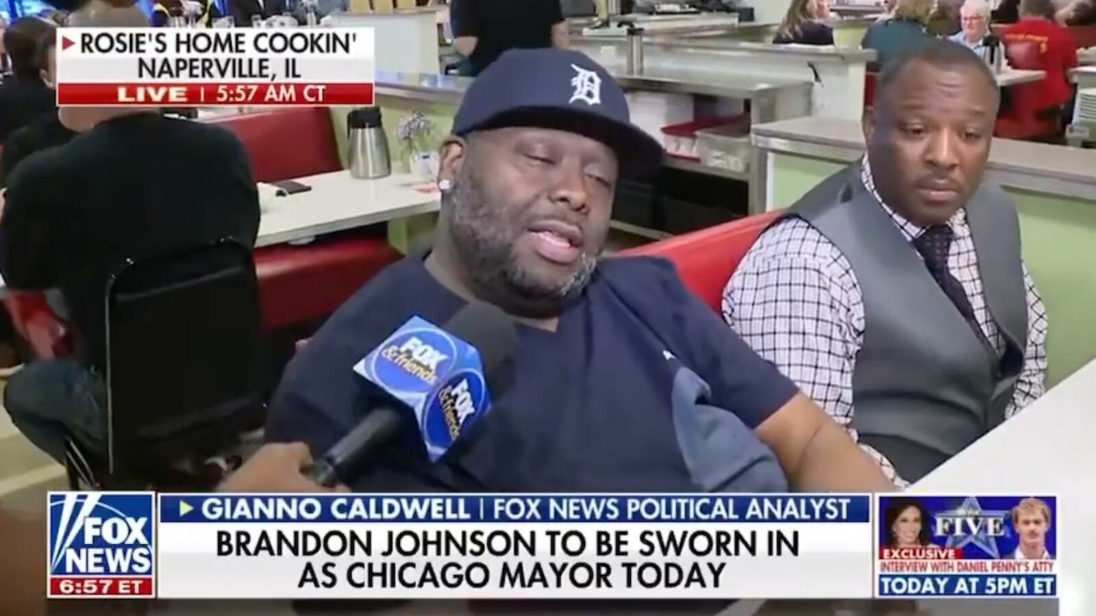 Caldwell interviewing a man, who is seated next to another man.