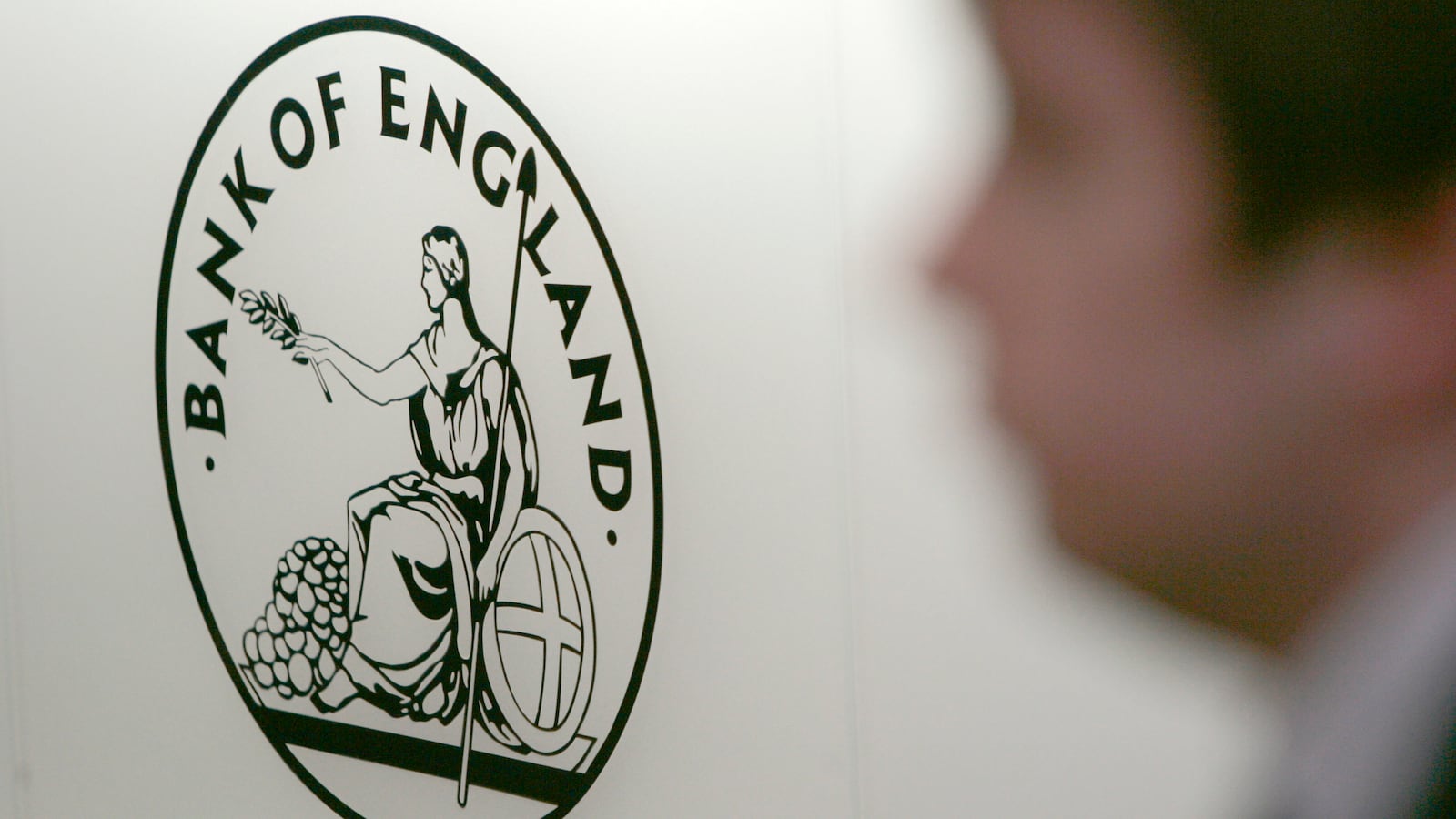 A man is seen walking past a sign in the reception area of the Bank of England, in London on March 25, 2008.