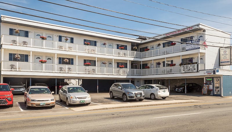 A three storey motel with cars in front
