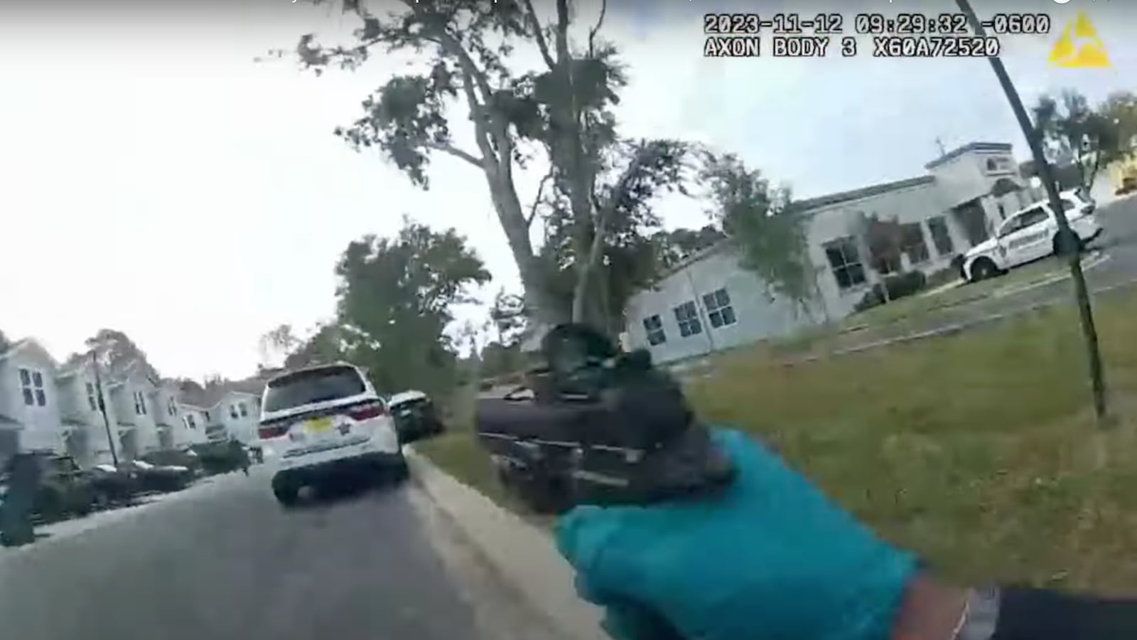 Screengrab from body-camera footage showing an officer with his gun drawn in the direction of his patrol vehicle.