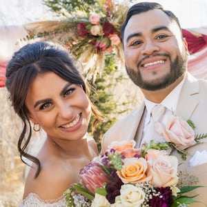 Bride and groom with best man and maid of honor posing at outdoor wedding