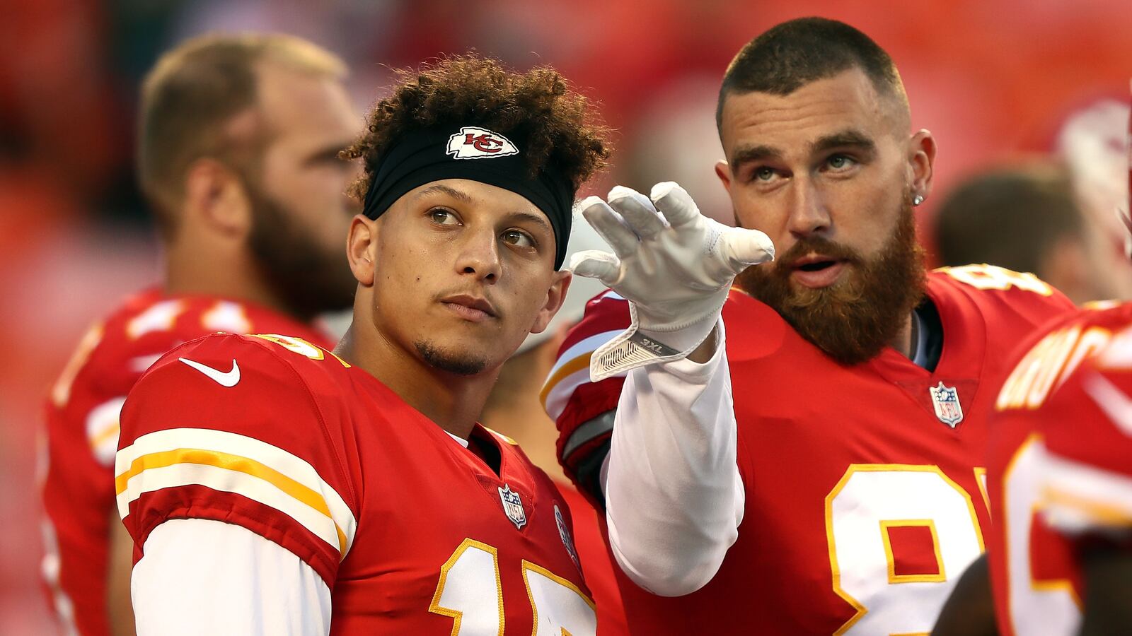 Quarterback Patrick Mahomes #15 and tight end Travis Kelce #87 of the Kansas City Chiefs scan the crowd during warm-ups prior to the preseason game against the Green Bay Packers at Arrowhead Stadium on August 30, 2018 in Kansas City, Missouri.
