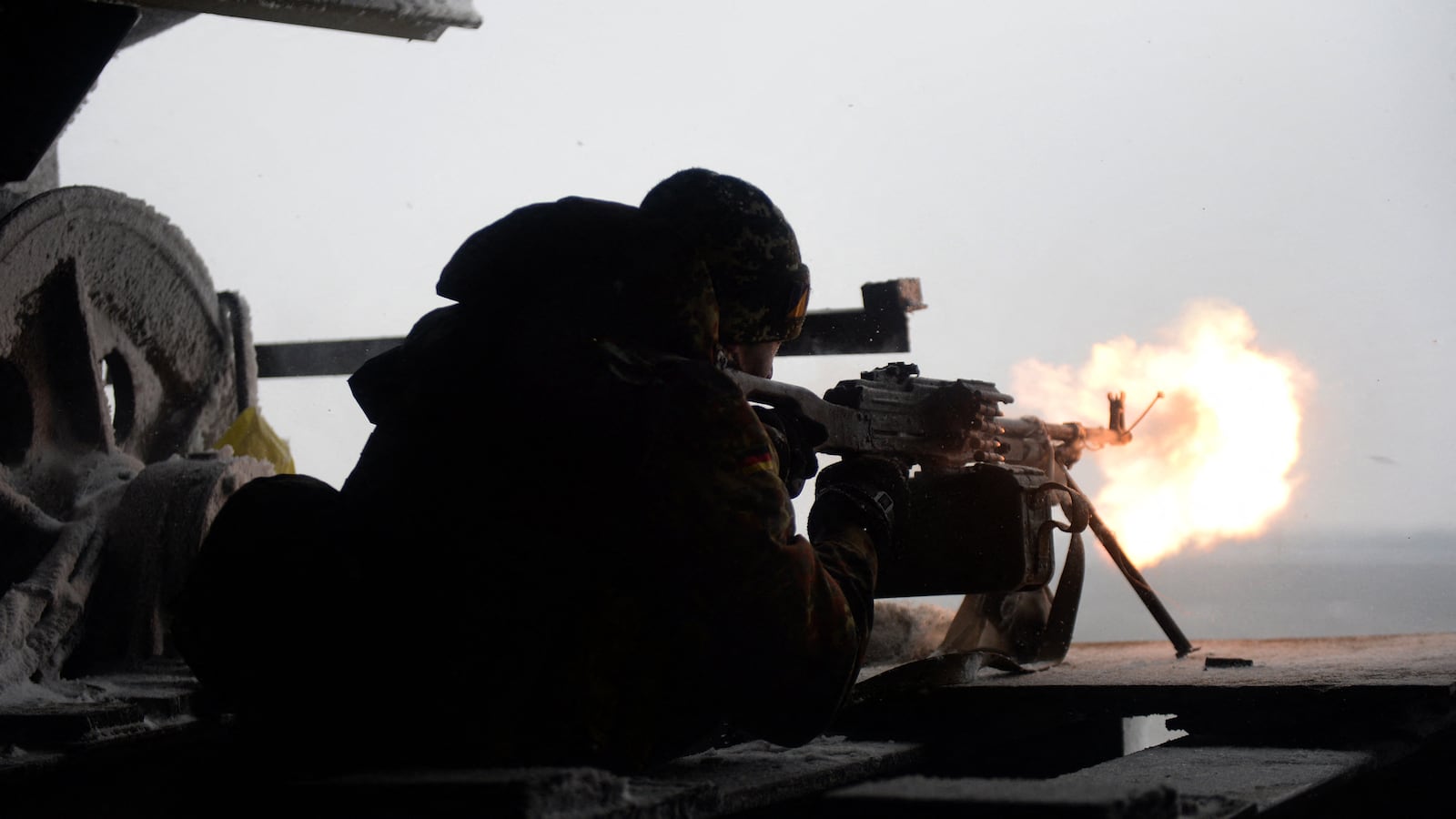 An Ukrainian Right Sector batallion volunteer fires a machine gun on January 3, 2015 from his position near the eastern Ukrainian village of Pisky, in the northeastern Donetsk region, at pro-Russian separatists near the Donetsk airport.