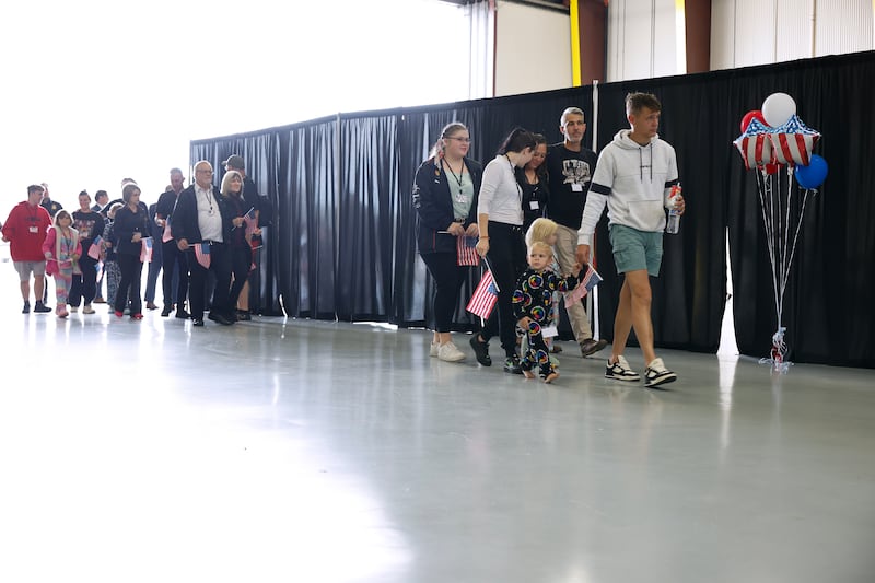 Newly arrived South Africans wait to hear welcome statements from U.S. government officials in a hangar at Atlantic Aviation Dulles near Washington Dulles International Airport on May 12, 2025 in Dulles, Virginia. Dozens of white South Africans, also called Afrikaners, accepted an invitation from the Trump Administration to come to the United States as refugees.