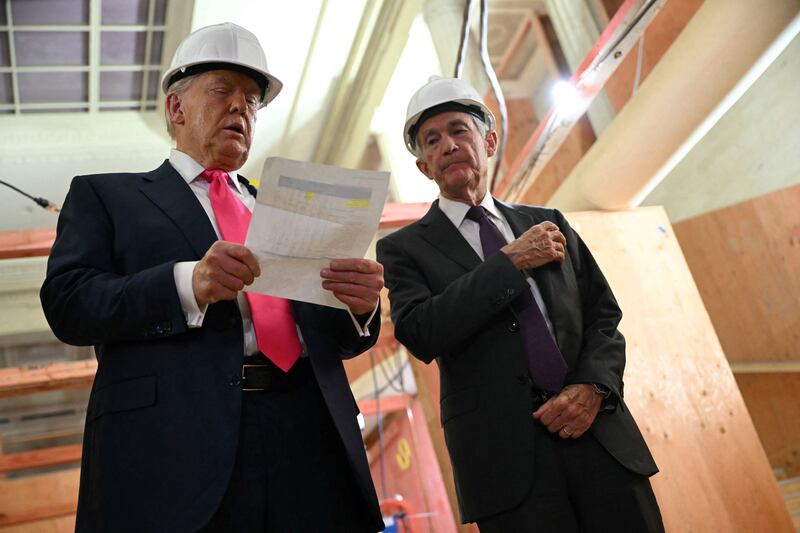 President Donald Trump speaks with Federal Reserve chair Jerome Powell (R) as he visits the Federal Reserve in Washington, DC, on July 24, 2025.