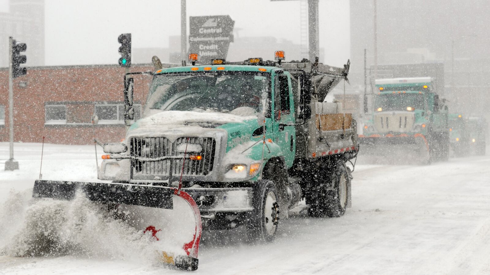 Snowplows clear a downtown street during a blizzard in Kansas City.