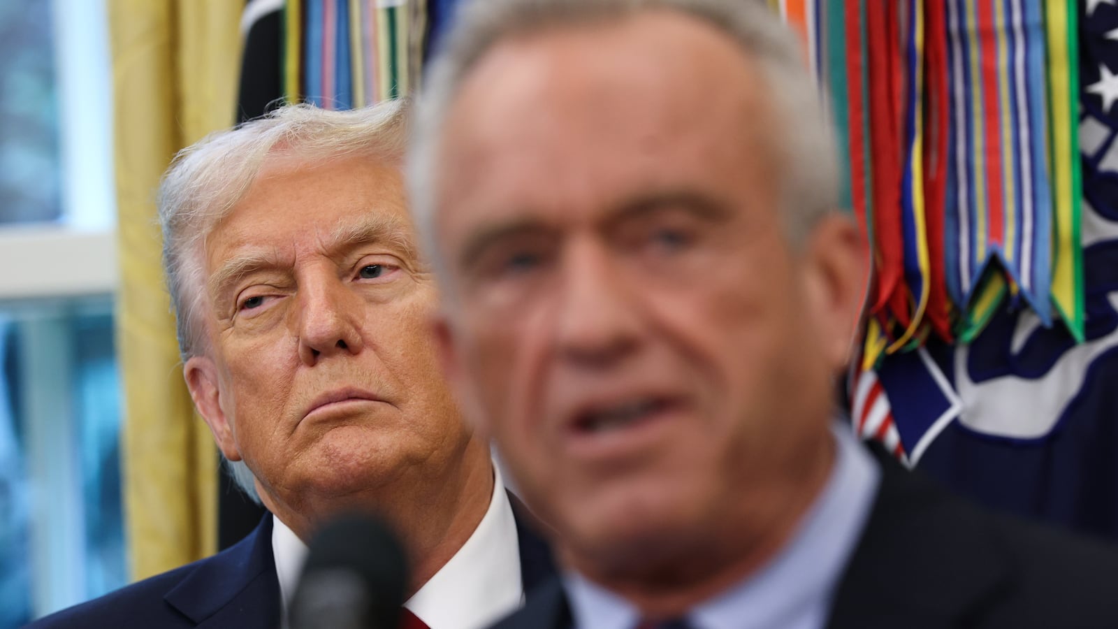 WASHINGTON, DC - SEPTEMBER 30: U.S. President Donald Trump listens as U.S. Secretary of Health and Human Services Robert F. Kennedy Jr. speaks after announcing a deal with Pfizer to lower Medicaid drug prices in the Oval Office of the White House on September 30, 2025 in Washington, DC. The Trump administration has reportedly reached an agreement with pharmaceutical company Pfizer to voluntarily sell its medications through Medicaid at lower prices. (Photo by Win McNamee/Getty Images)