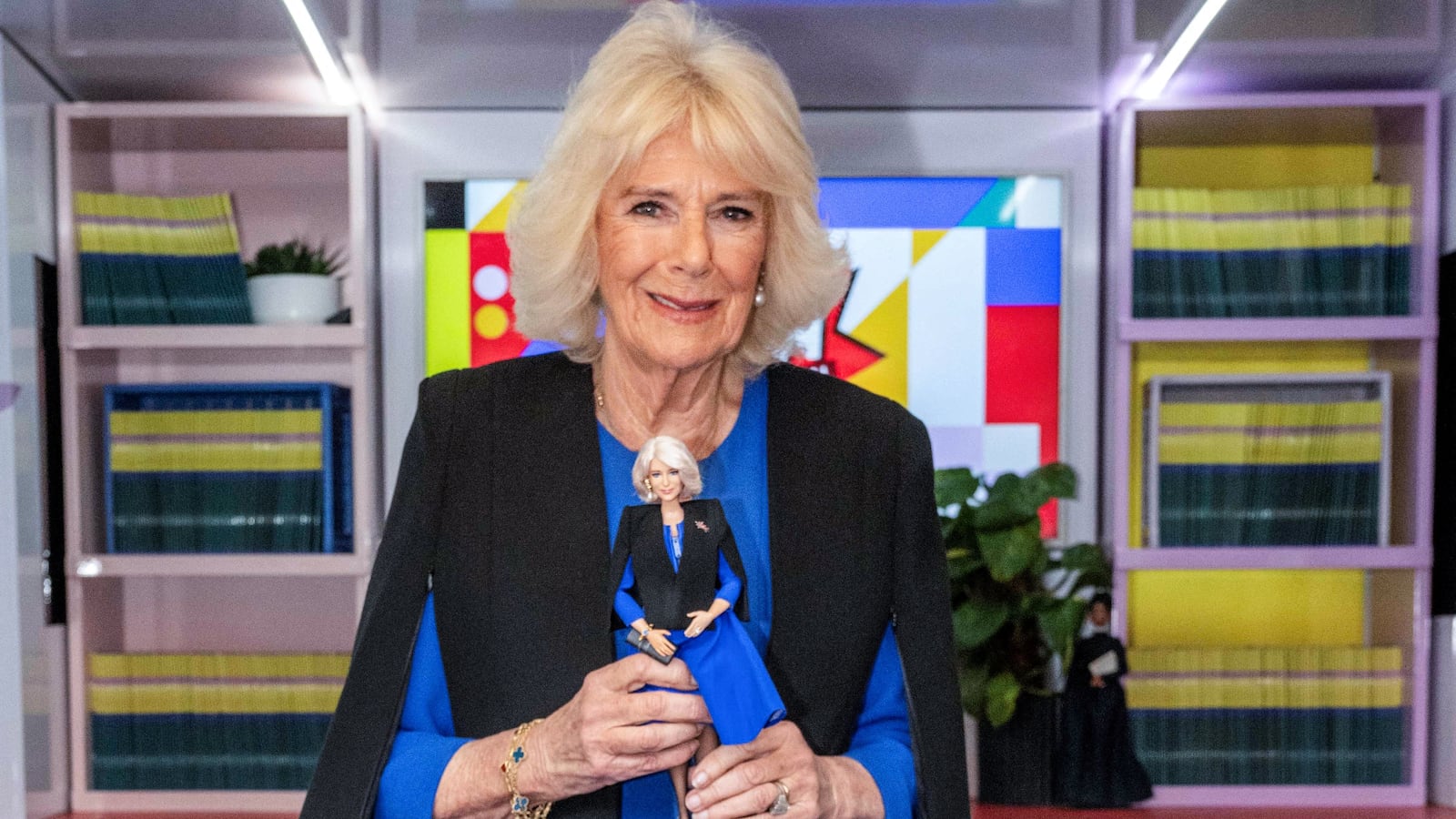 Queen Camilla holds a Barbie doll in her image during a reception to celebrate International Women's Day and mark the end of the Women of the World (WOW) Girls Festival Bus tour at Buckingham Palace on March 12, 2024.