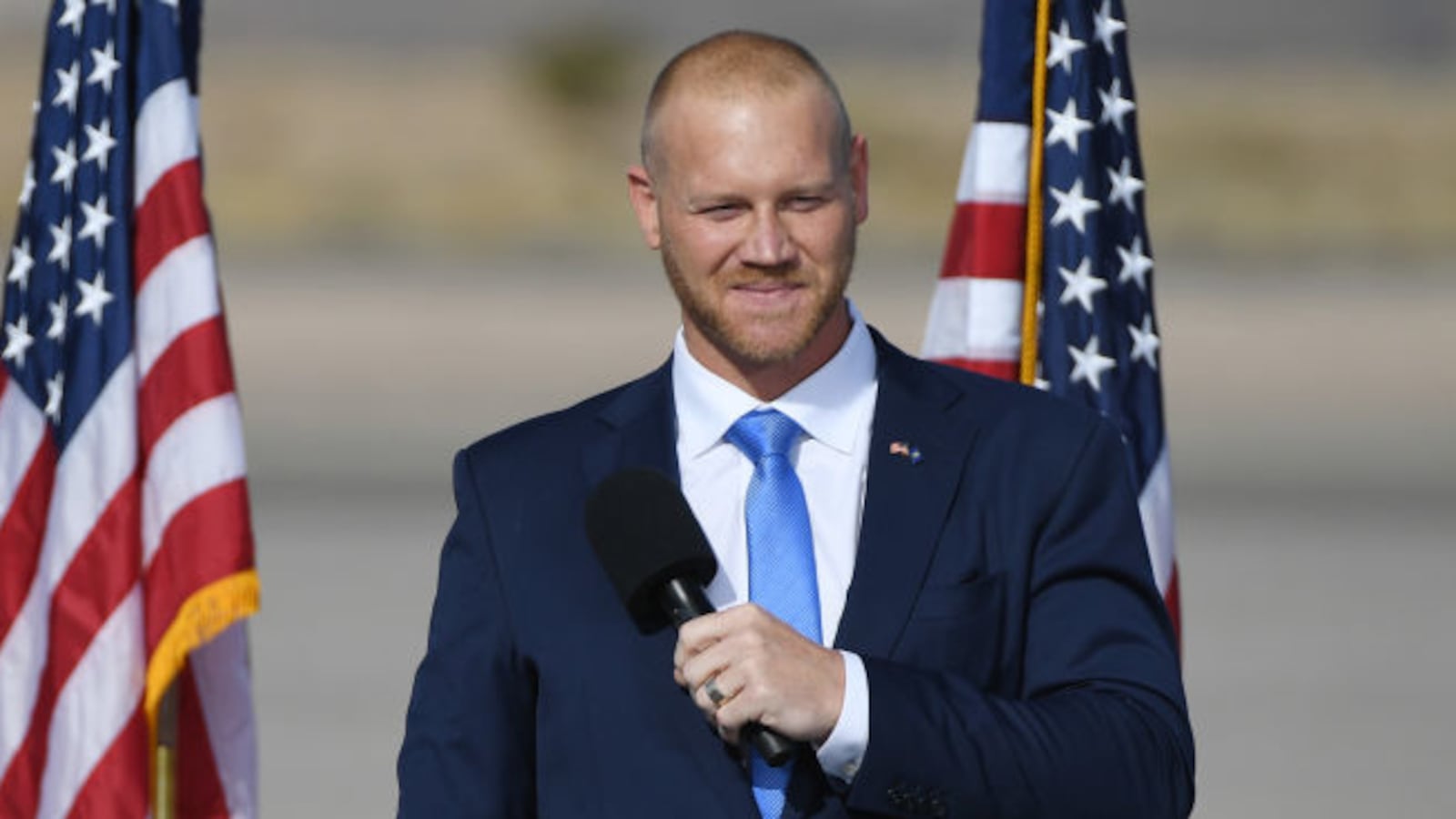 Daniel Rodimer speaks on stage at an outdoor campaign event.