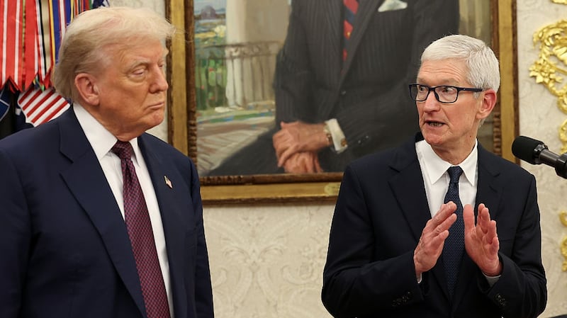 WASHINGTON, DC - AUGUST 06: Apple CEO Tim Cook (R) speaks as U.S. President Donald Trump looks on during an event in the Oval Office of the White House on August 6, 2025 in Washington, DC. Apple Inc. announced a $100 billion investment in manufacturing facilities in the U.S., on top of an announcement in February committing over the next four years to a $500 billion investment in the U.S. economy and the addition of 20,000 new jobs. (Photo by Win McNamee/Getty Images)