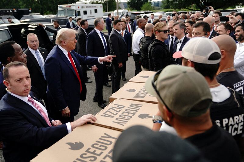 U.S. President Donald Trump points as he stands in front of pizza boxes, as he attends U.S. Park Police Anacostia Operations Facility to meet with police and the military, after deploying National Guard troops in the nation's capital, in Washington, D.C., U.S., August 21, 2025.