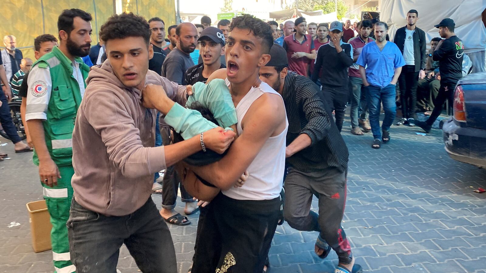 Palestinians carry a casualty of Israeli strikes at Al Shifa hospital Gaza City November 9, 2023.