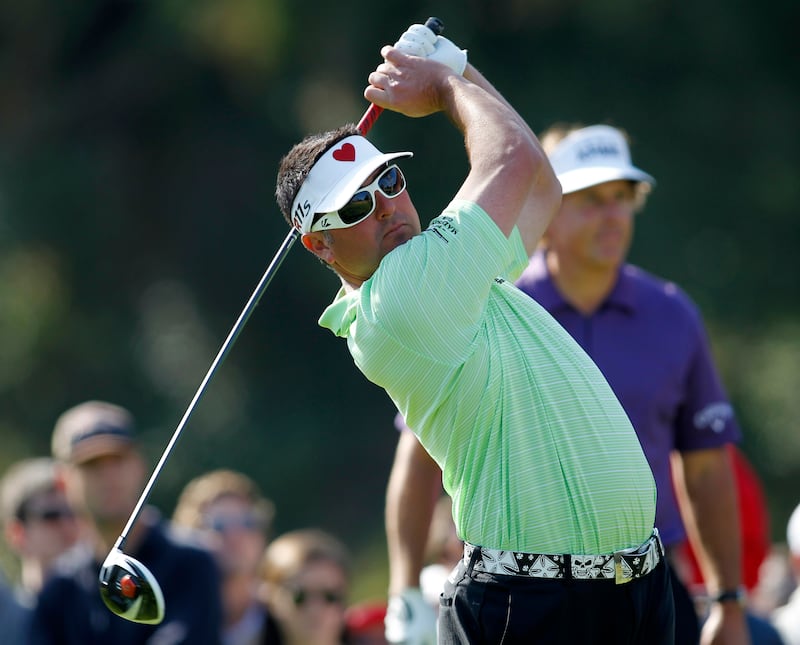 Pat Perez tees off as Phil Mickelson looks on from the background at a tournament in 2012, when the two men were still reportedly friends.