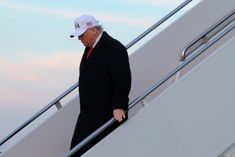 U.S. President Donald Trump walks down the air stairs after landing on Air Force One on January 13, 2026 at Joint Base Andrews, Maryland.