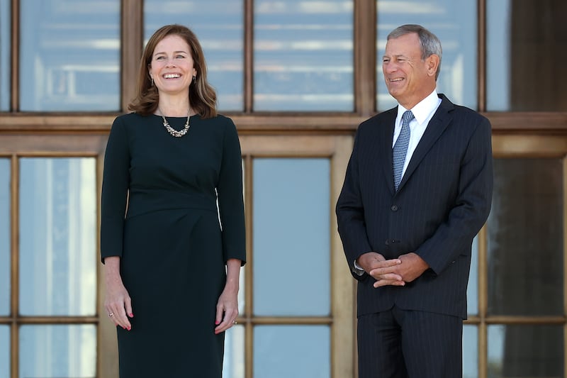 Supreme Court Associate Justice Amy Coney Barrett (L) and Chief Justice John Roberts pause for photographs at the top of the steps of the west side of the Supreme Court following her investiture ceremony on October 01, 2021 in Washington, DC.