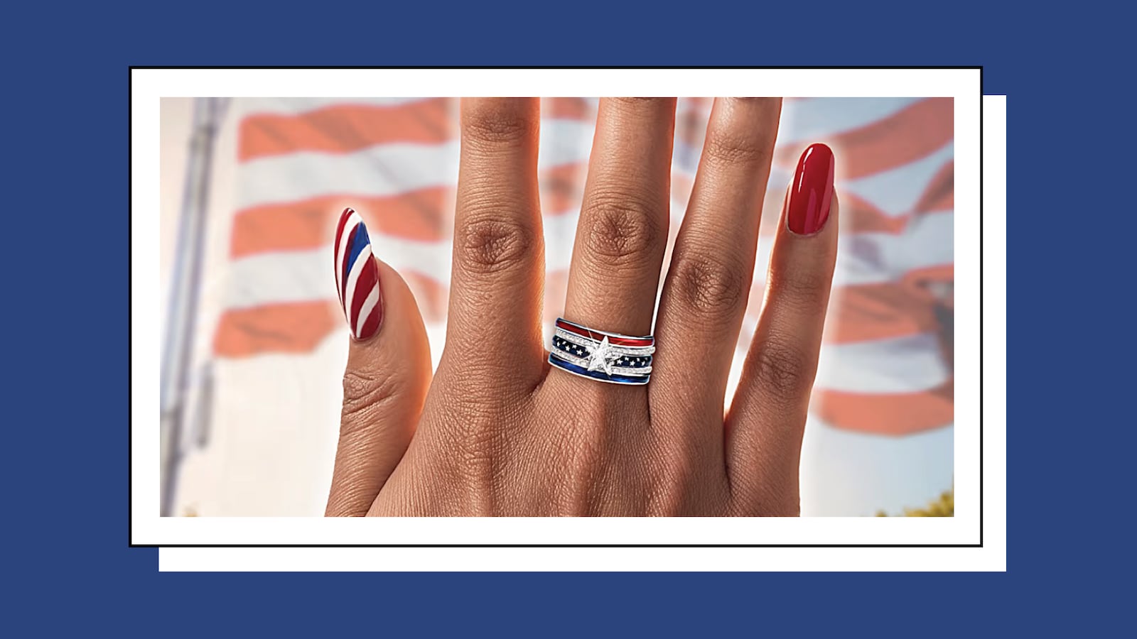 Close-up of a hand wearing a patriotic star-shaped ring with red, white, and blue banding, set against a blurred American flag background.