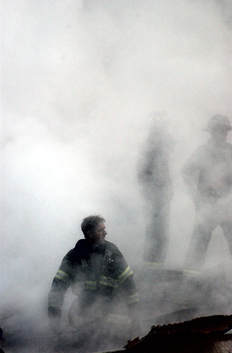 A firefighter emerging from the smoke and debris of the World Trade Center 14 September, 2001.