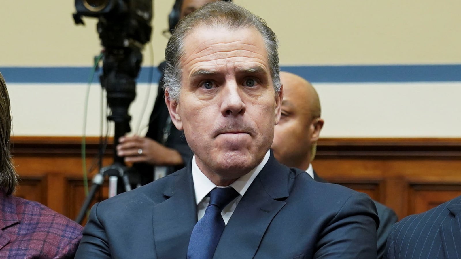 Hunter Biden, wearing a suit and tie, crosses his arm during a hearing.