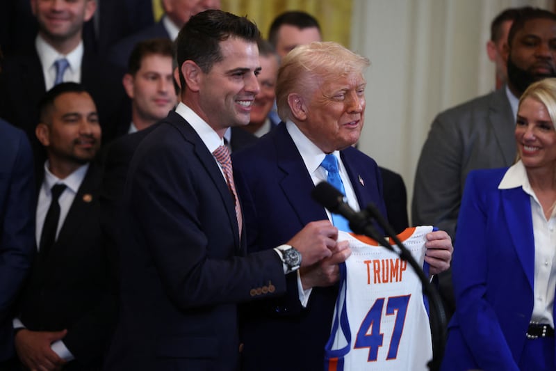 Florida Gators Head Coach Todd Golden presents U.S. President Donald Trump with a team jersey with the number 47, as Trump welcomes the team, the 2025 NCAA Men's Division I Basketball Champions at the White House, in Washington, D.C., U.S., May 21, 2025.