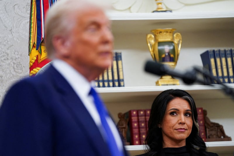 Incoming Director of National Intelligence Tulsi Gabbard looks at U.S. President Donald Trump during her swearing in ceremony as DNI in the Oval Office at the White House in Washington, D.C., U.S., February 12, 2025.